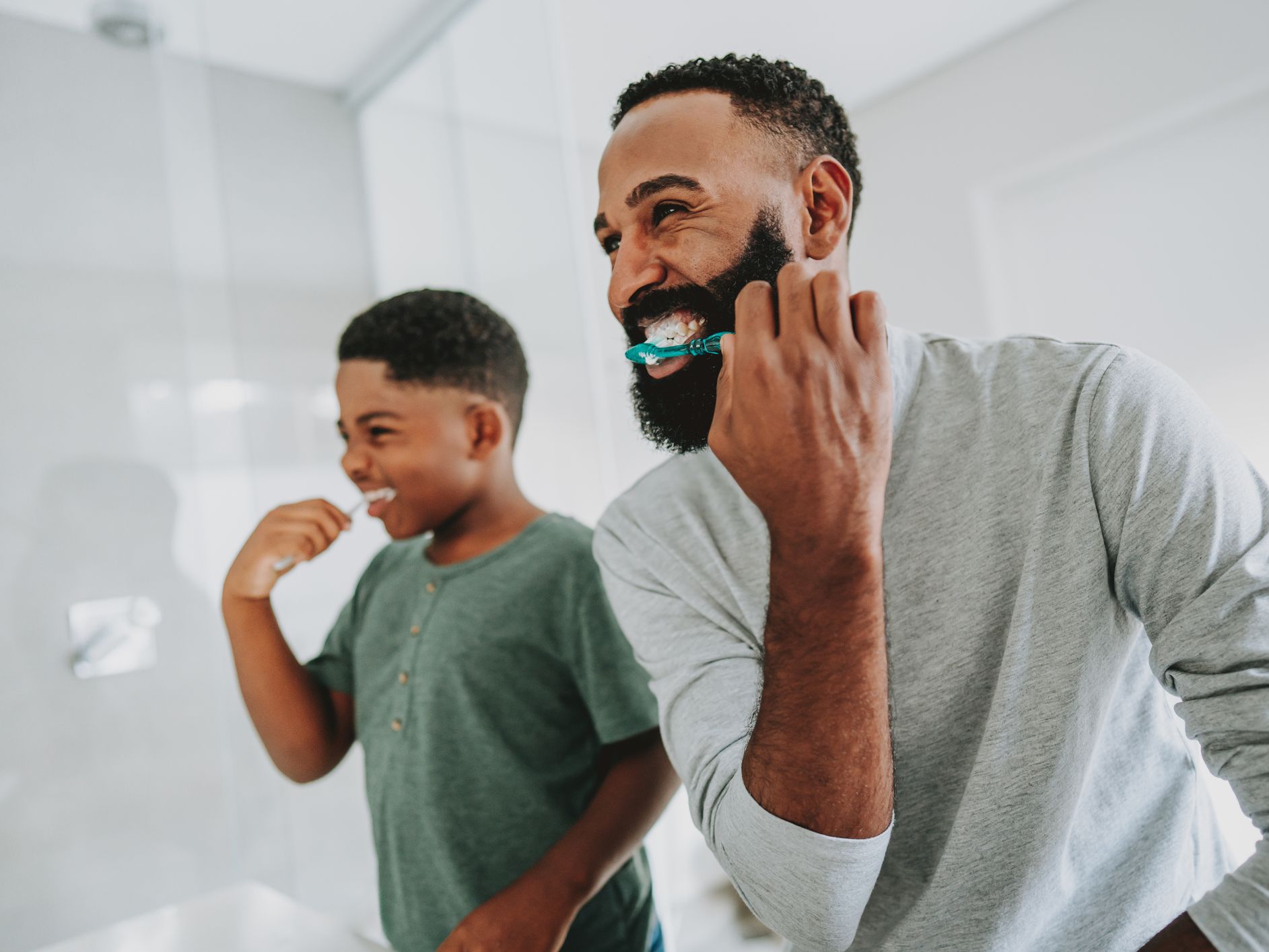 Father and son brushing teeth in an allergy friendly healthier bathroom